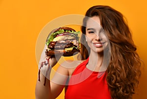 Woman hold big burger sandwich in hand hungry mouth getting ready to eat