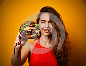 Woman hold big burger sandwich in hand hungry mouth getting ready to eat