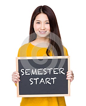 Woman hold blackboard showing phrases of semester start