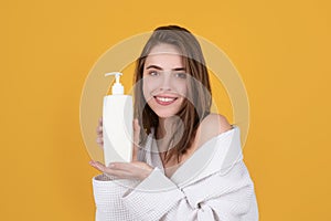 Woman hold bottle shampoo and conditioner. Young brunette woman with nourished long hair, studio shot. Beauty product