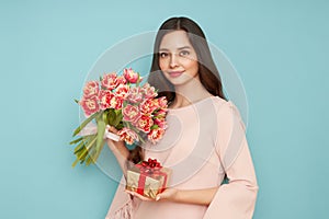 Woman hold bouquet of flowers and golden gift box
