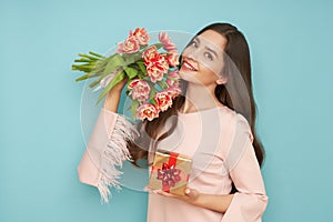 Woman hold bouquet of flowers and golden gift box