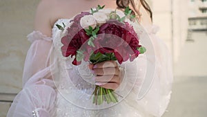 Woman hold bouquet of red flowers. Bride in wedding day.