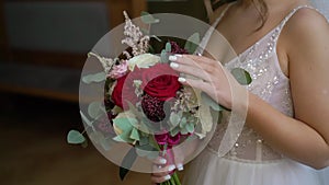 Woman hold bouquet of white and red flowers. Bride in wedding day.