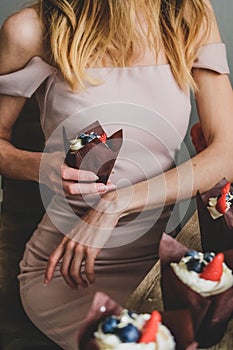 Woman hold chocolate cake in hand.