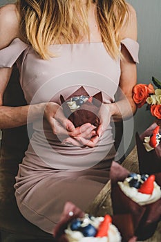 Woman hold chocolate cake in hand.