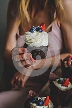 Woman hold chocolate cake in hand.