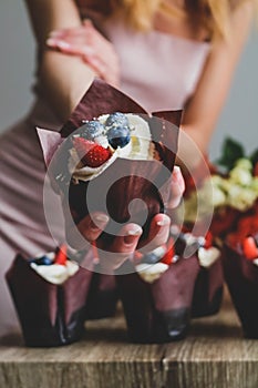 Woman hold chocolate cake in her hand.