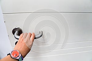 Woman hold doorknob for open the door with left hand
