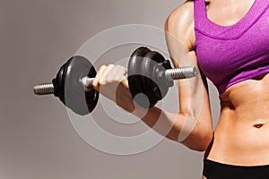 Woman hold dumbbell with strong hand and fit body