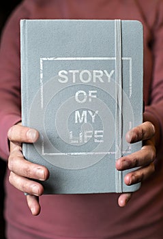 Woman hold notebook. Book notes for the Story of my life. Personal memoirs notes concept