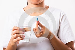 Woman hold pill drugs in hand ready take medicines with a glass of water