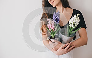 Woman hold pots with flowers on white background.