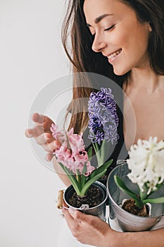 Woman hold pots with flowers on white background.