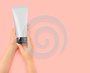 Woman hold tube with a cosmetic product in her hands. Skin care concept, Soft Silky Healthy Skin. Beauty And Health. pink