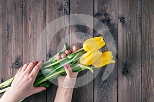 Woman hold yellow tulips