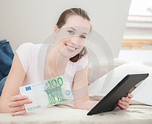 Woman holding 100 euro and tablet device