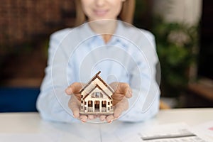 Woman holding 3d model of house in hands