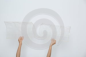 Woman holding air conditioner filters near white wall, closeup