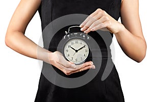 Woman holding alarm clock in hands, isolated on white