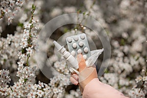 Woman holding allergy pills, drugs and nose spray against kind of an allergies during spring time, helathcare concept