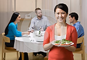 Woman holding appetizer and serving friends