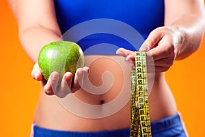 Woman holding apple and meter. People, fitness and healthcare concept