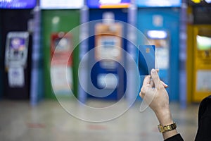 Woman holding an ATM card The background is a variety of ATMs