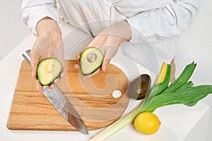 Woman holding avocado halves in her hands