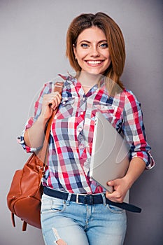 Woman holding bag and laptop