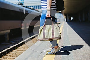 Woman holding a bag at a railway station