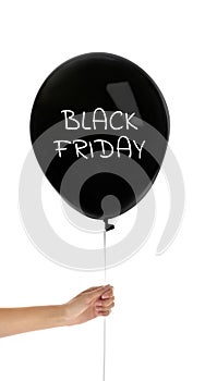 Woman holding balloon with text BLACK FRIDAY on background, closeup