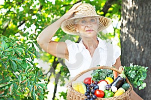 Woman holding a basket with fruits and vegetables