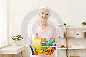 Woman Holding a Basket Full of Cleaning Products