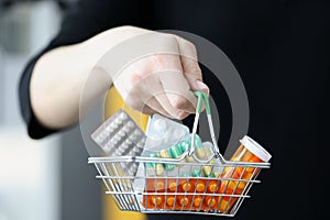 Woman holding basket of medicines in her hand closeup