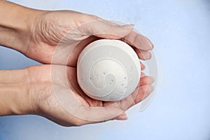 Woman holding bath bomb over foam