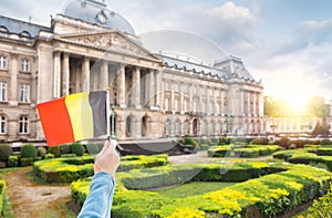 Woman holding Belgium flag in the background of the royal palace in Brussels