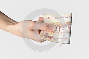 Woman holding Bhutanese Ngultrum notes in her hand