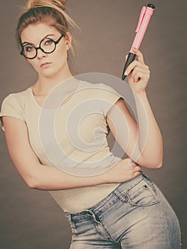 Woman holding big oversized pencil thinking about something