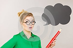 Woman holding big oversized pencil thinking