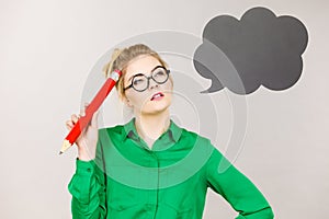 Woman holding big oversized pencil thinking