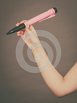 Woman holding big pen