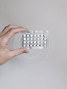 A woman holding birth control pills