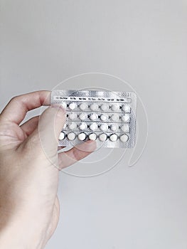 A woman holding birth control pills