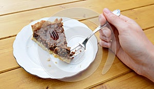 Woman holding a bite of pecan pie on her fork