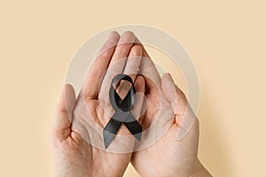 Woman holding black Ribbon for symbol Melanoma and skin cancer. Narcolepsy, Primary Biliary Cirrhosis, Sleep Apnea