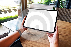 A woman holding black tablet pc with blank white desktop screen