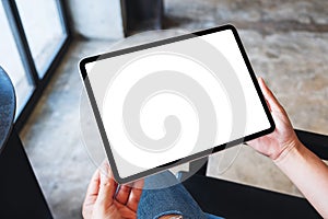 A woman holding black tablet pc with blank white desktop screen