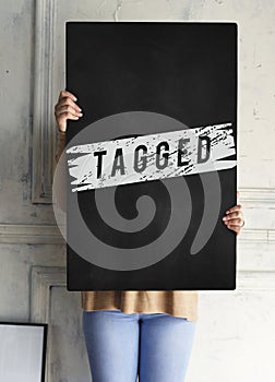 Woman holding black tagged board