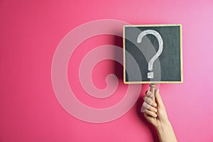 Woman holding blackboard with question mark on background, closeup. Space for text